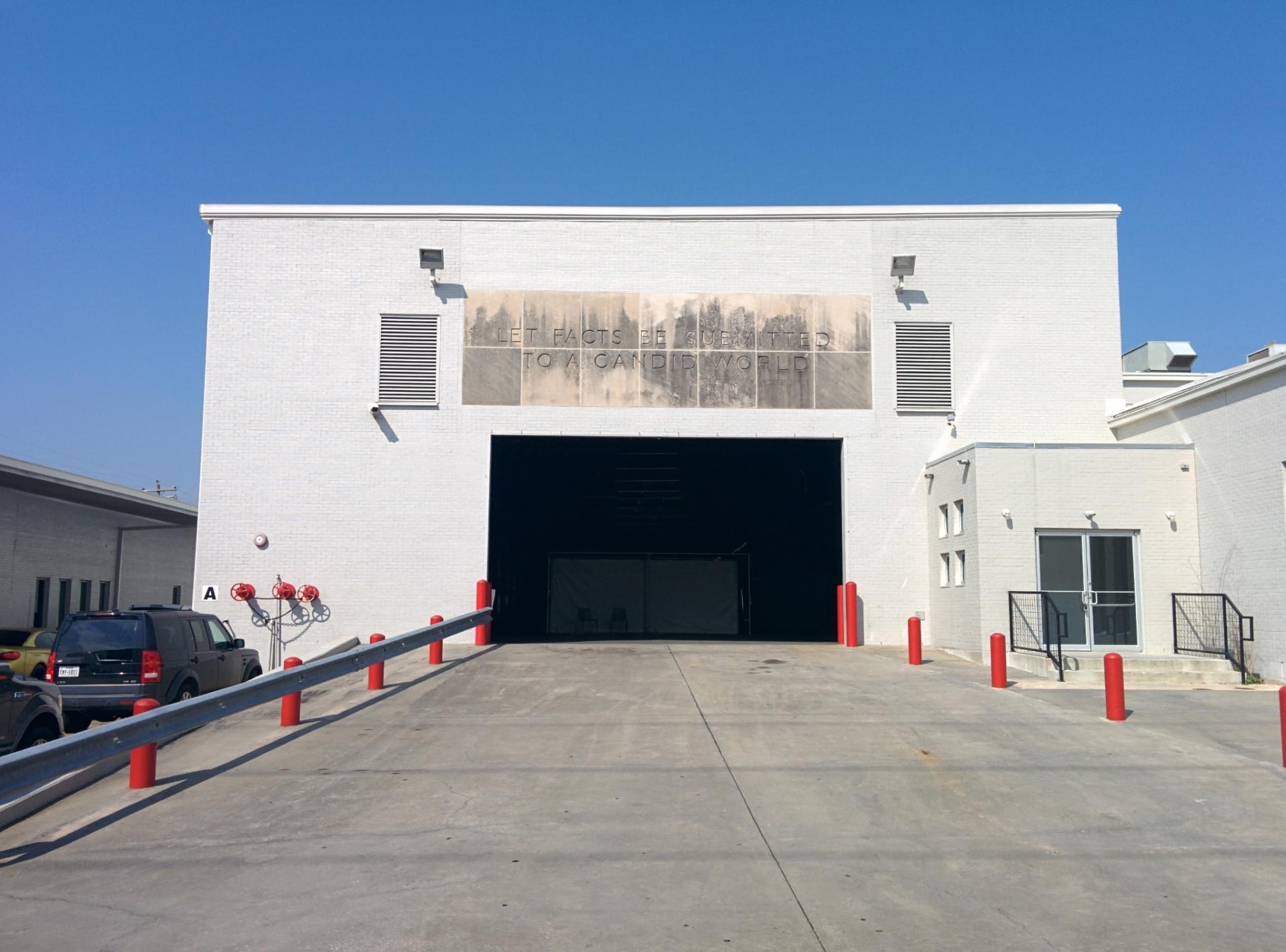 White industrial exterior and loading entrance at Silver Street Studios during the exploratory Day for Night 2015 site visit.