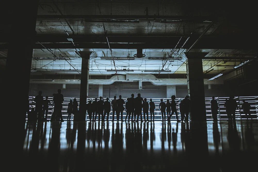 Festival crowd silhouetted in the dark industrial interior of Day for Night, Houston
