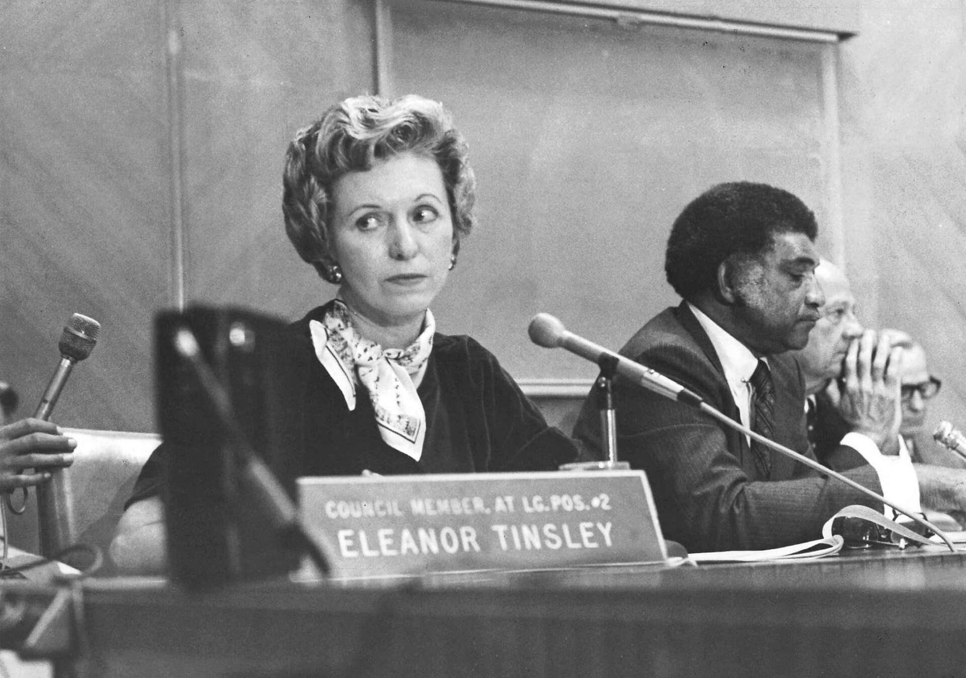Eleanor Tinsley seated at a Houston City Council meeting behind a nameplate reading COUNCIL MEMBER, AT LG. POS. #2 ELEANOR TINSLEY.