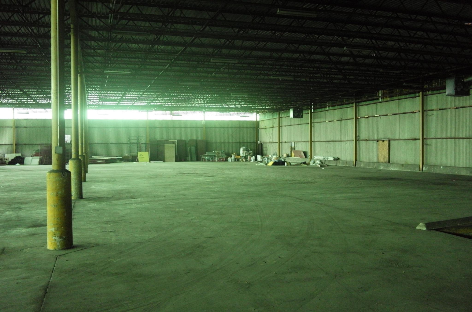 Unlit warehouse interior with steel columns and clerestory light during the exploratory Day for Night 2015 site visit.