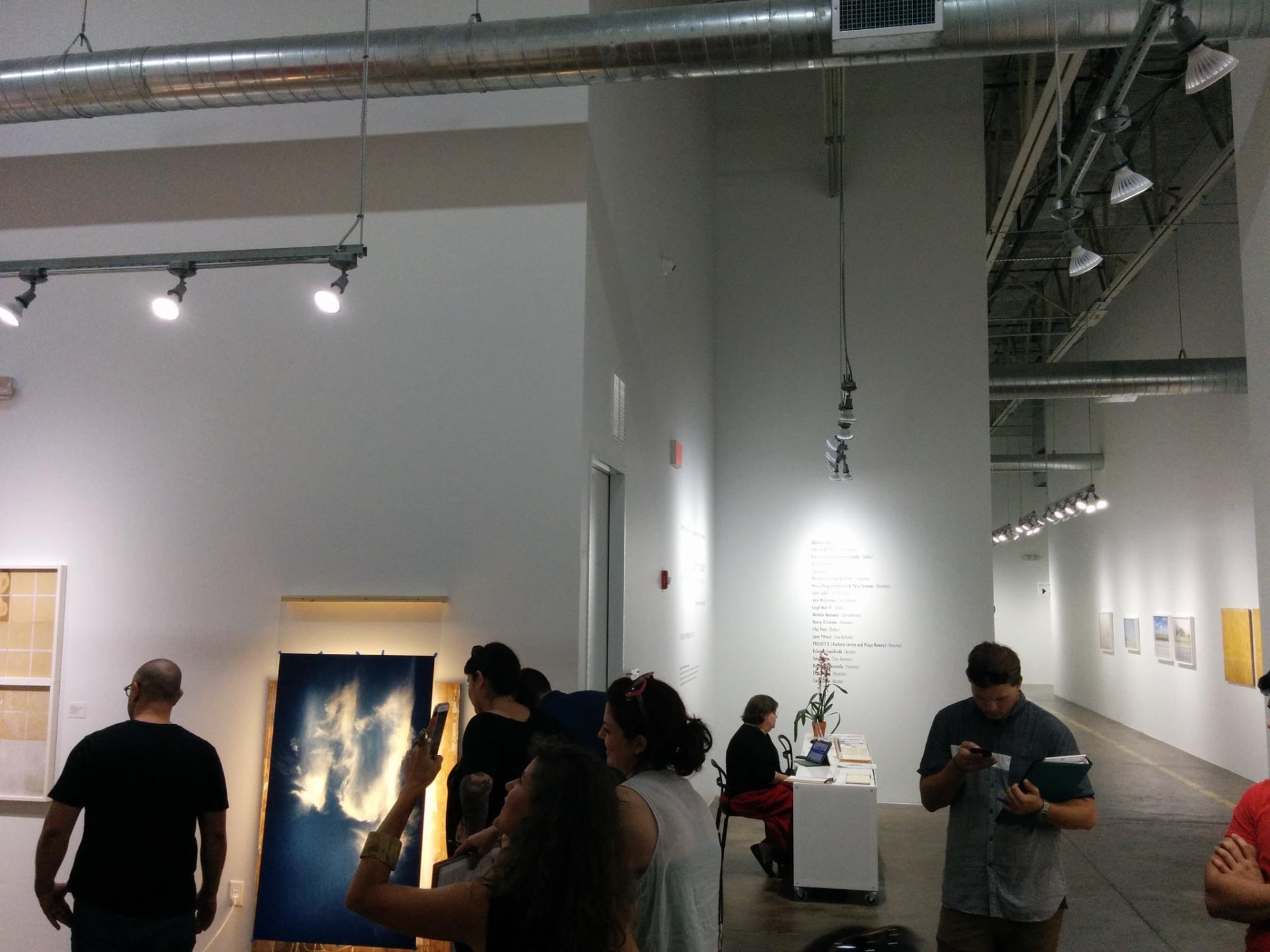 Visitors and artwork in an exhibition space at Silver Street Studios during the exploratory Day for Night 2015 site visit.
