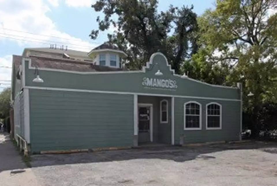 Day exterior of Mango's on Westheimer in Montrose, the venue's arched green facade and signage facing the street.