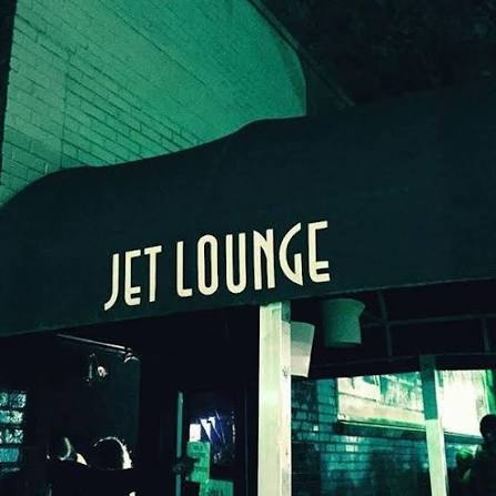Night exterior of Jet Lounge at 1515 Pease Street, the venue's awning sign above the door.