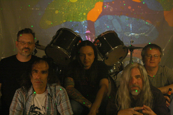 The Linus Pauling Quartet group portrait with drum kit and projected backdrop