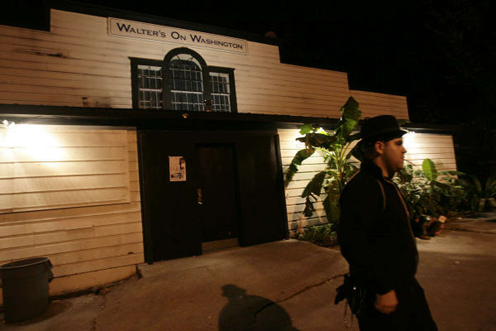 The exterior of Walter's on Washington at night, its sign above the door.