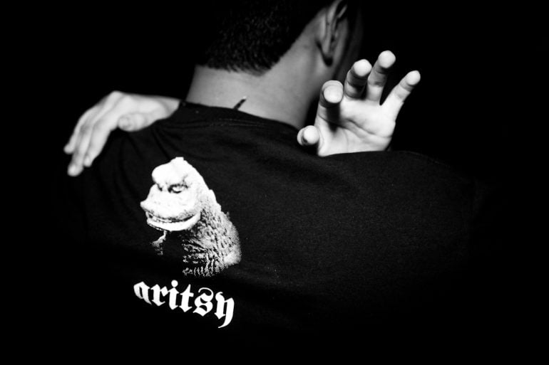 Black-and-white photo of a Suraj K t-shirt with a lizard graphic.