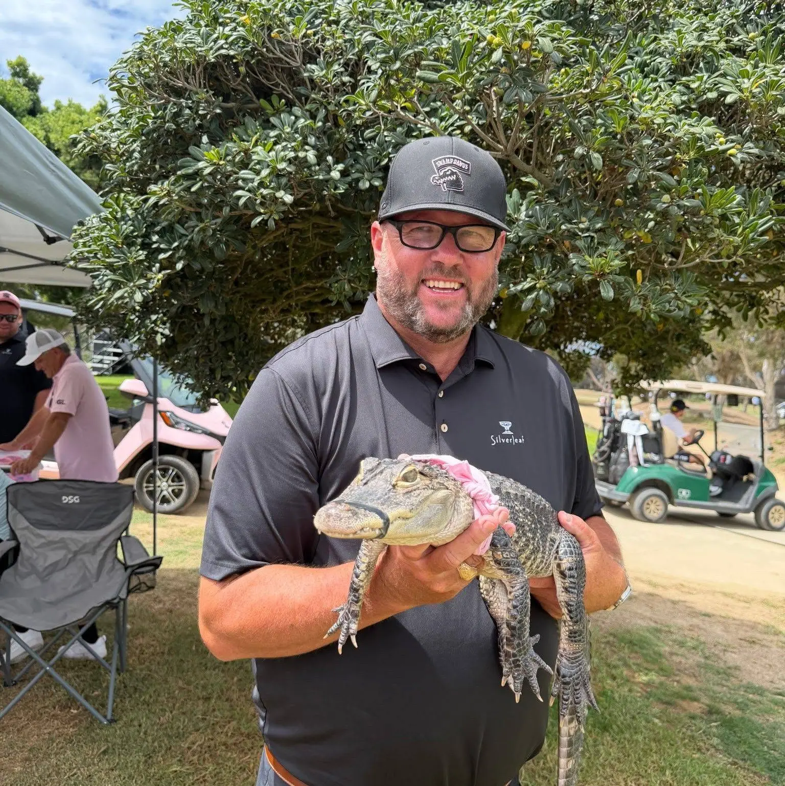 Scott ‘Flash’ Faber outdoors, holding a small alligator.